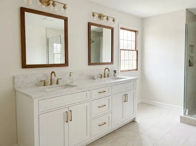 Illustration of a bathroom with a white double vanity, marble-look stone top and gold faucets